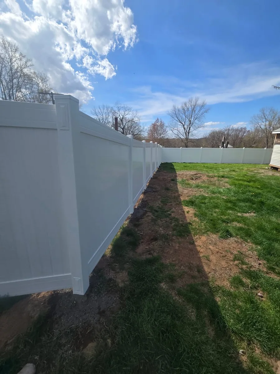 Close view down white vinyl fence line