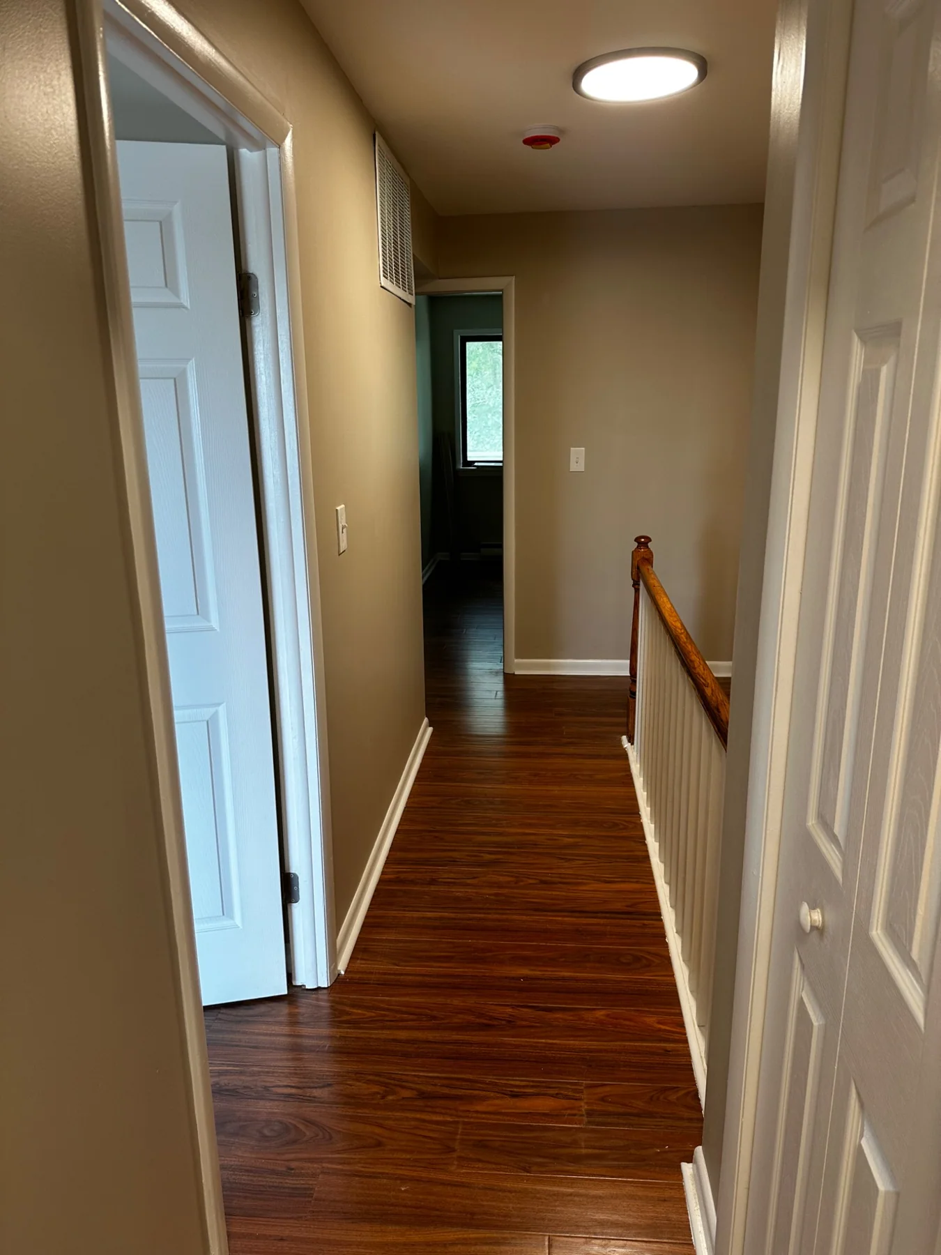 Completed LVP flooring in hallway leading into another room